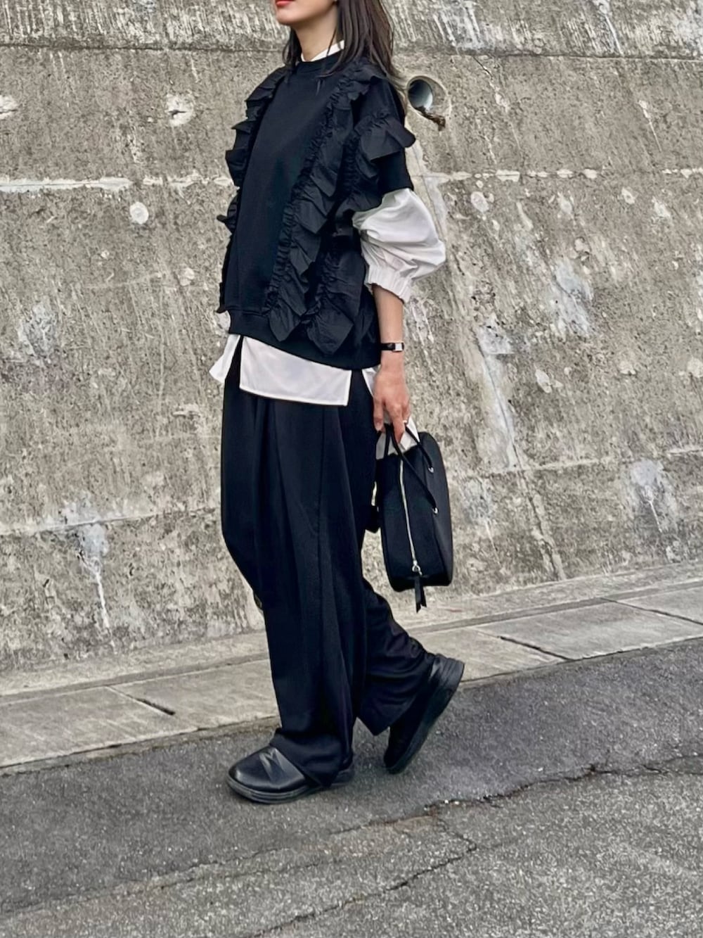 ブラック系のボストンバッグ、ブラック系のスラックス、ブラック系のスウェットを着用したレディースの春コーディネートの2枚目の写真