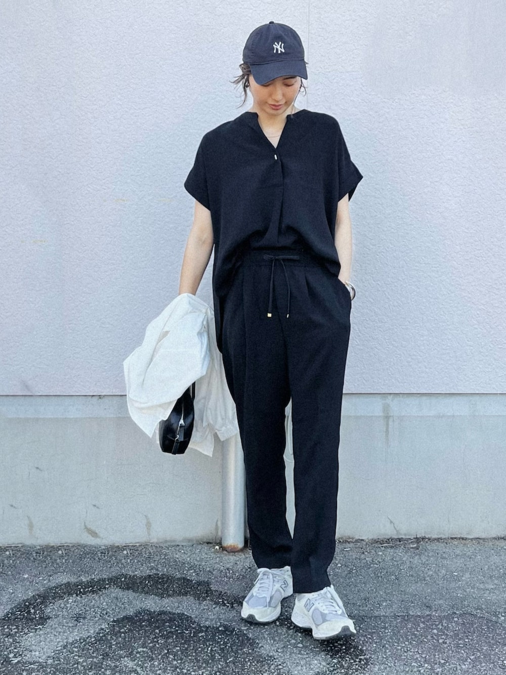 ブラック系のシャツ/ブラウス、グレー系のスニーカー、ブラック系のボストンバッグを着用したレディースの春コーディネートの2枚目の写真