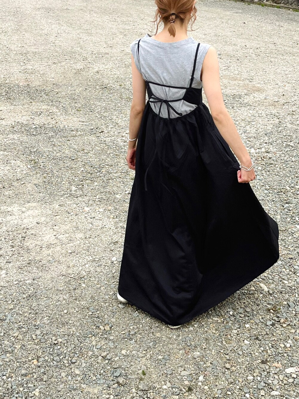 ブラック系のワンピース、グレー系のタンクトップ、ホワイト系のスニーカーを着用したレディースの春コーディネートの3枚目の写真