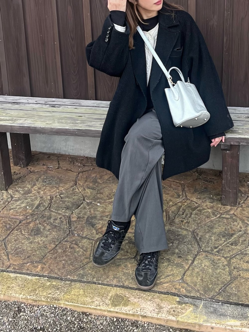 シルバー系のハンドバッグを着用したレディースの冬コーディネートの3枚目の写真