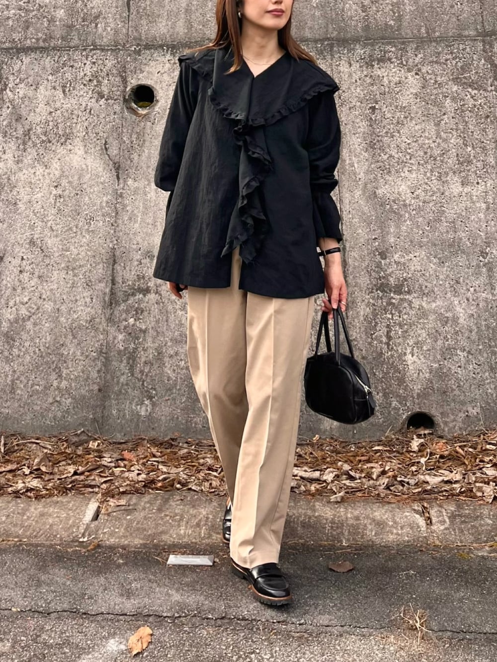 ブラック系のシャツ/ブラウス、ベージュ系のチノパンツを着用したレディースの冬コーディネートの3枚目の写真