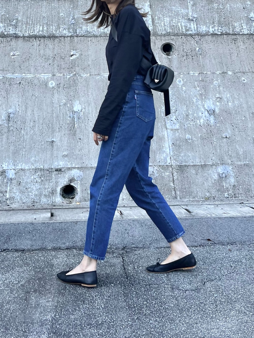 ブラック系のTシャツ/カットソー、ブラック系のハンドバッグ、ブラック系のバレエシューズを着用したレディースの秋コーディネートの2枚目の写真