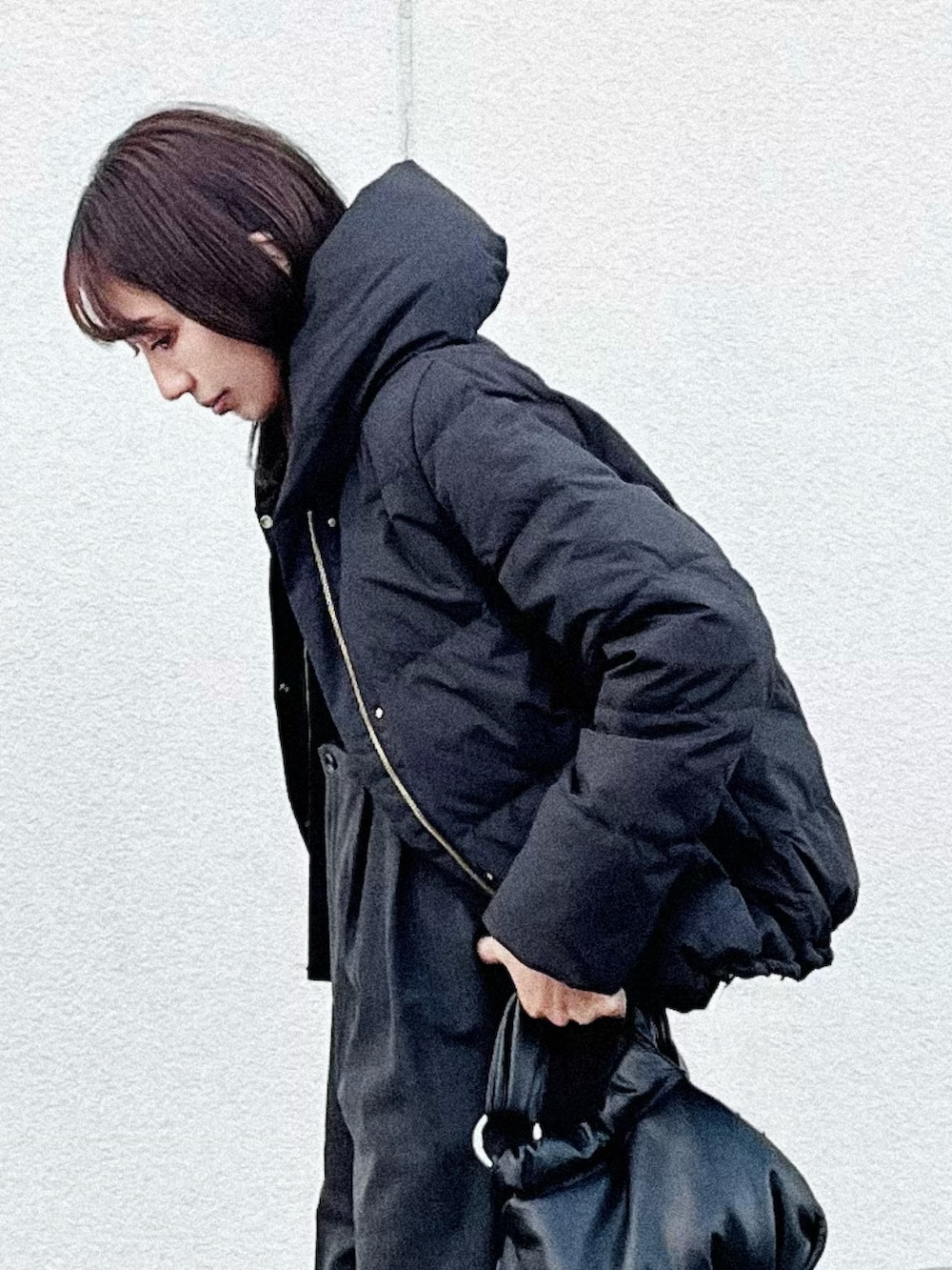 ブラック系のダウンジャケット/コート、グレー系のその他パンツ、ブラック系のハンドバッグを着用したレディースの秋コーディネートの2枚目の写真