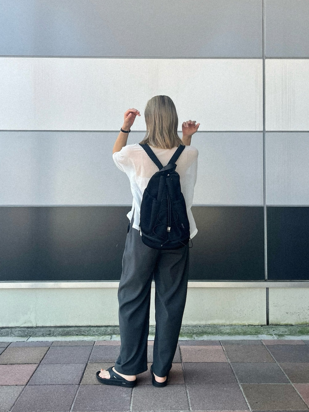 ブラック系のバックパック/リュック、ホワイト系のTシャツ/カットソー、ベージュ系のキャミソールを着用したレディースの夏コーディネートの2枚目の写真