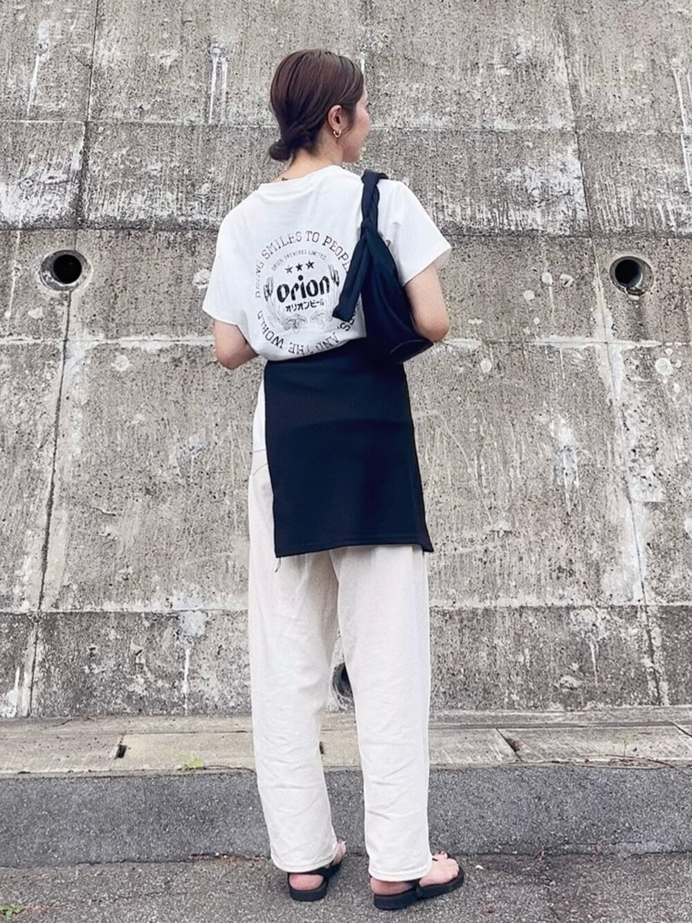 ホワイト系のTシャツ/カットソー、ホワイト系のデニムパンツ、ブラック系のサンダルを着用したレディースの夏コーディネートの2枚目の写真
