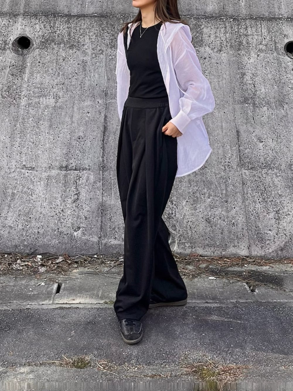 ホワイト系のシャツ/ブラウス、ブラック系のスラックスを着用したレディースの春コーディネートの2枚目の写真