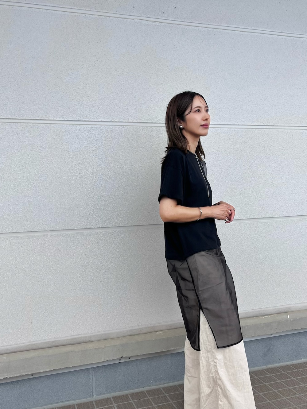 ブラック系のTシャツ/カットソー、ベージュ系のセットアップ、ブラック系のサンダルを着用したレディースの夏コーディネートの2枚目の写真