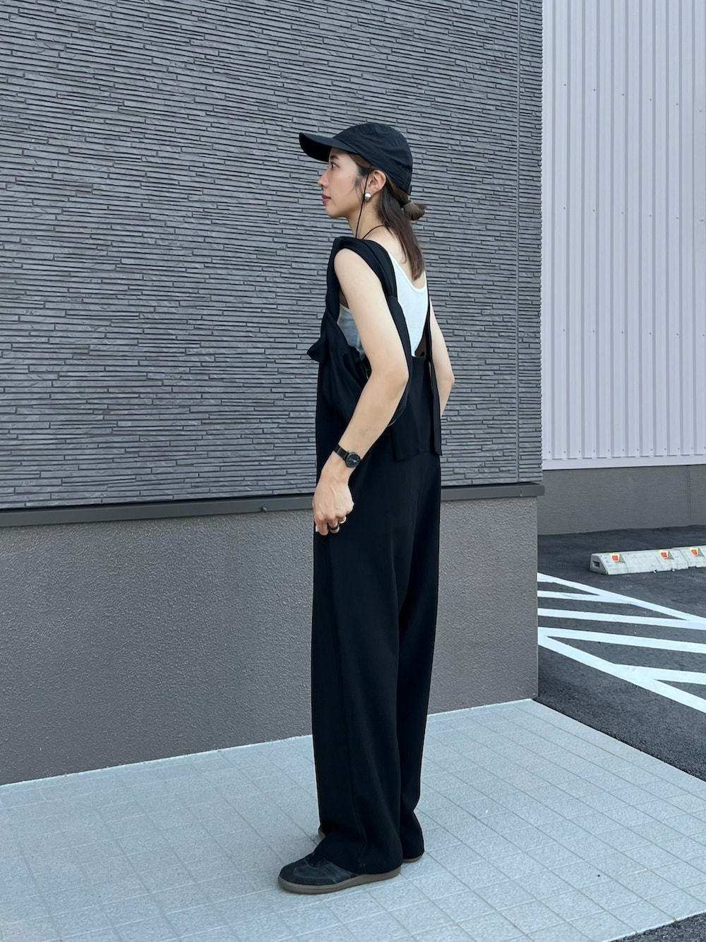 ブラック系のサロペット/オーバーオール、ブラック系のスニーカー、ホワイト系のタンクトップを着用したレディースの夏コーディネートの2枚目の写真