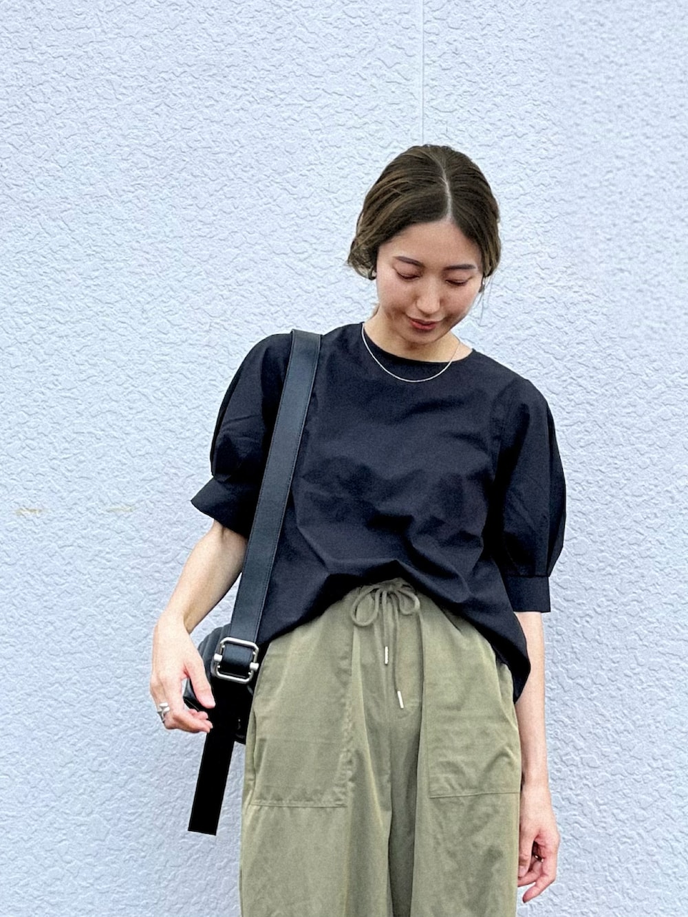 ブラック系のシャツ/ブラウス、ブラック系のサンダル、ブラック系のハンドバッグを着用したレディースの夏コーディネートの2枚目の写真