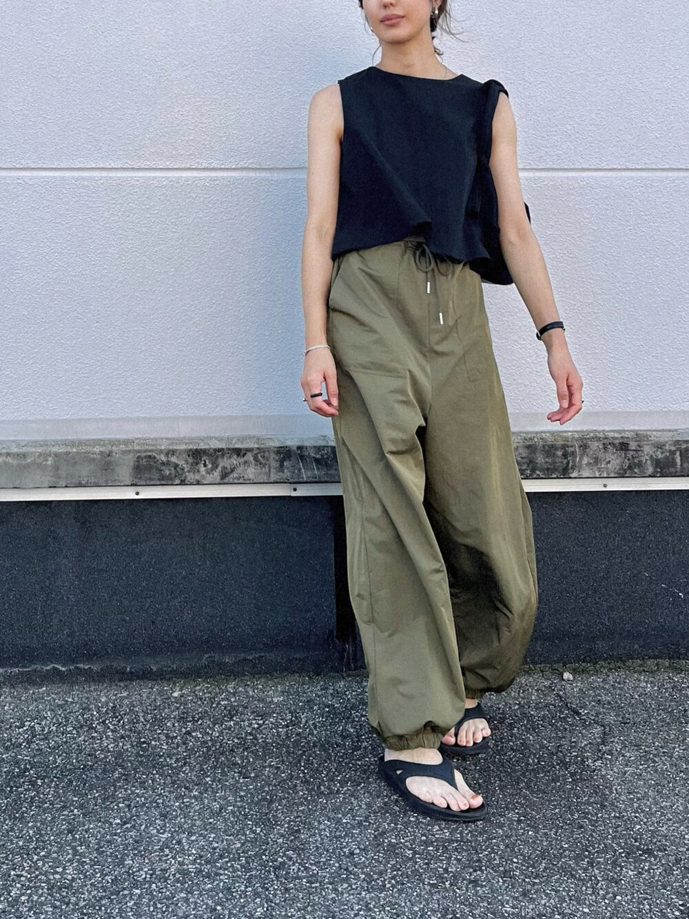 グリーン系のカーゴパンツ、ブラック系のセットアップ、ブラック系のサンダルを着用したレディースの夏コーディネートの2枚目の写真