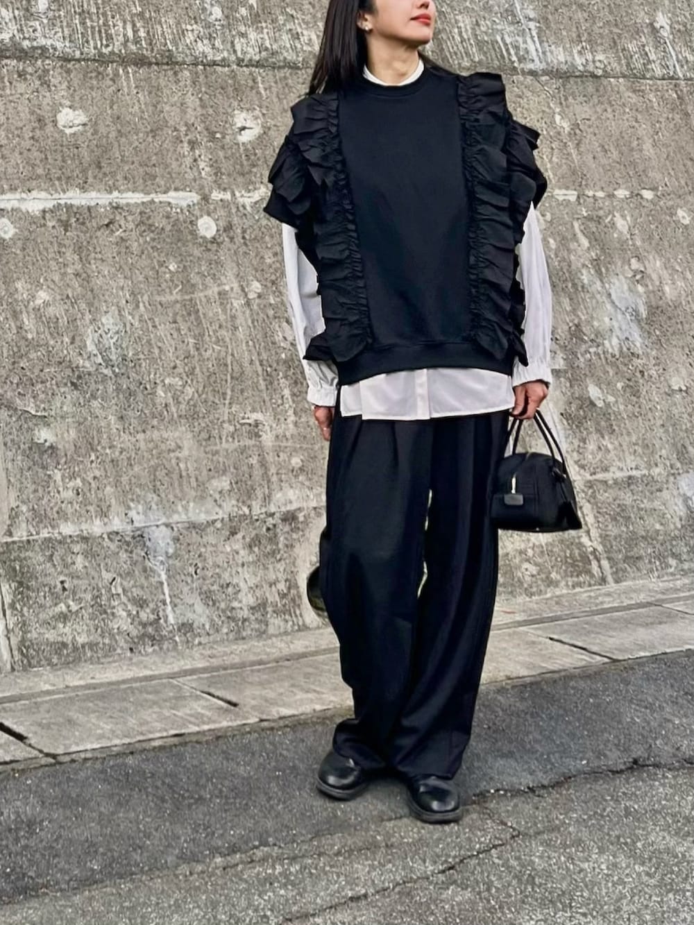 ブラック系のボストンバッグ、ブラック系のスラックス、ブラック系のスウェットを着用したレディースの春コーディネートの3枚目の写真