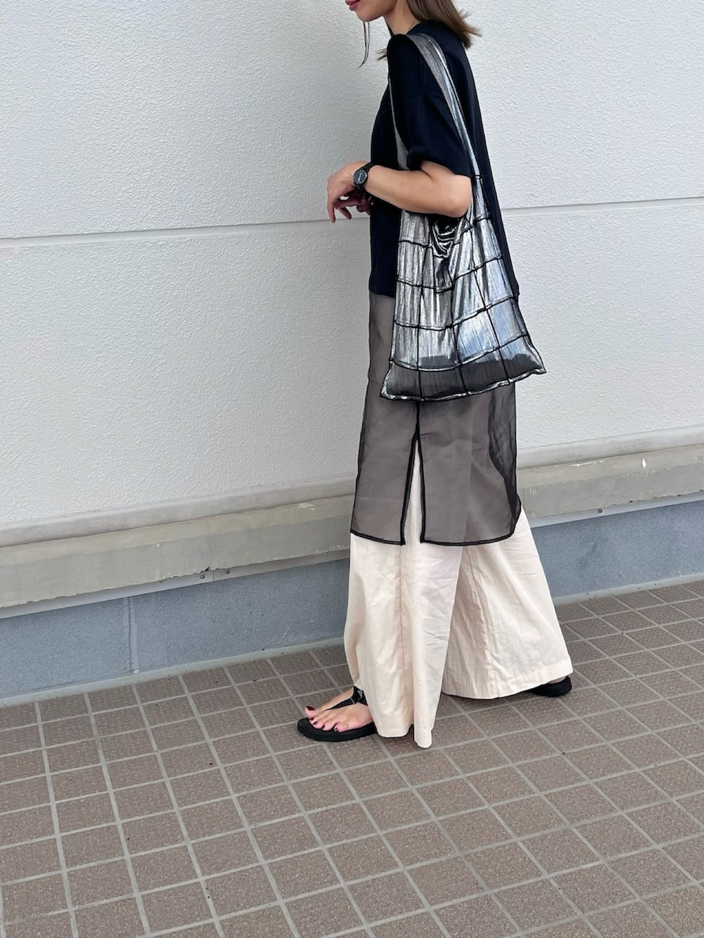 ブラック系のTシャツ/カットソー、ベージュ系のセットアップ、ブラック系のサンダルを着用したレディースの夏コーディネートの3枚目の写真