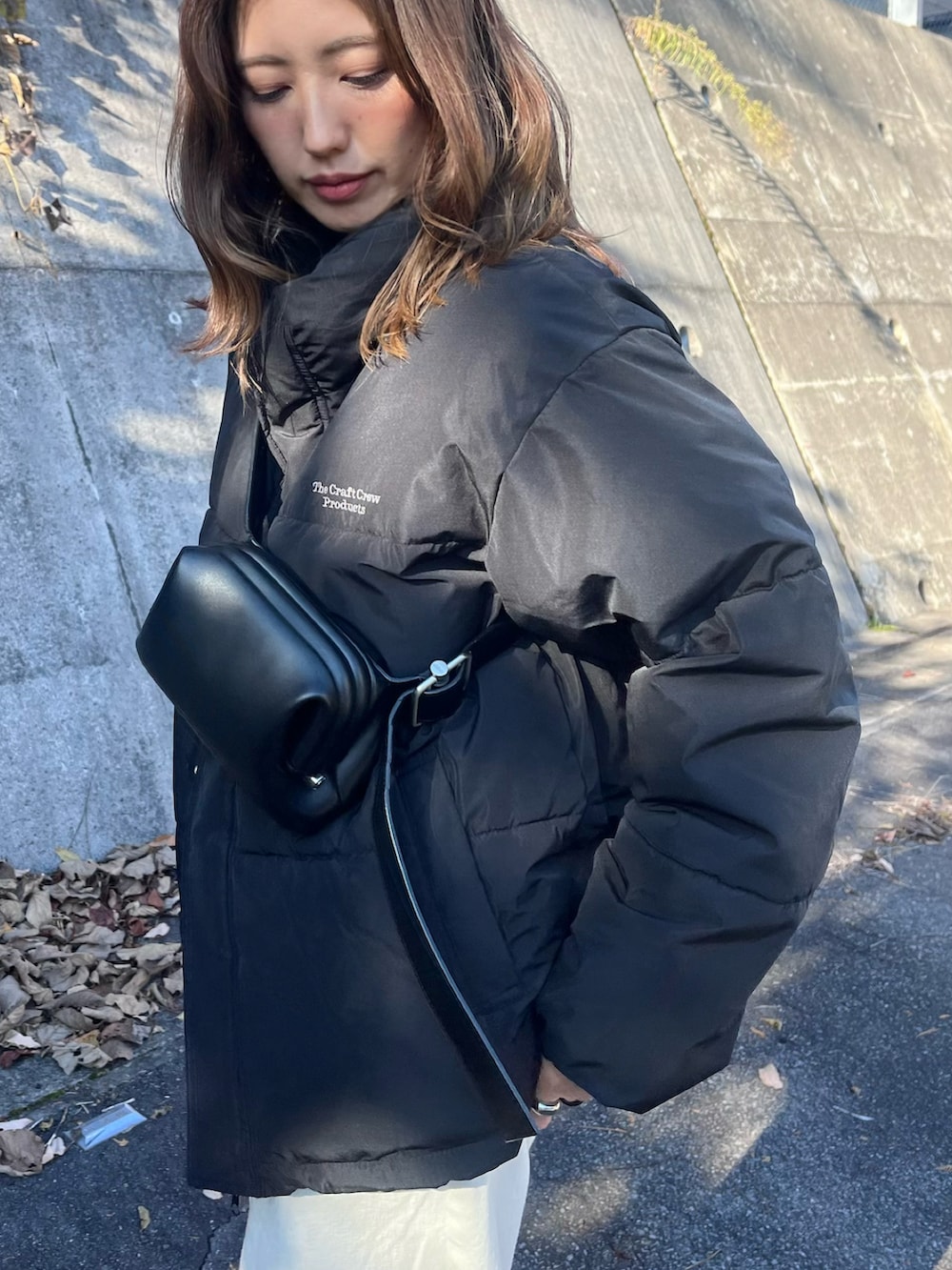 ブラック系のダウンジャケット/コート、ホワイト系のデニムパンツ、ブラック系のスニーカーを着用したレディースの秋コーディネートの4枚目の写真