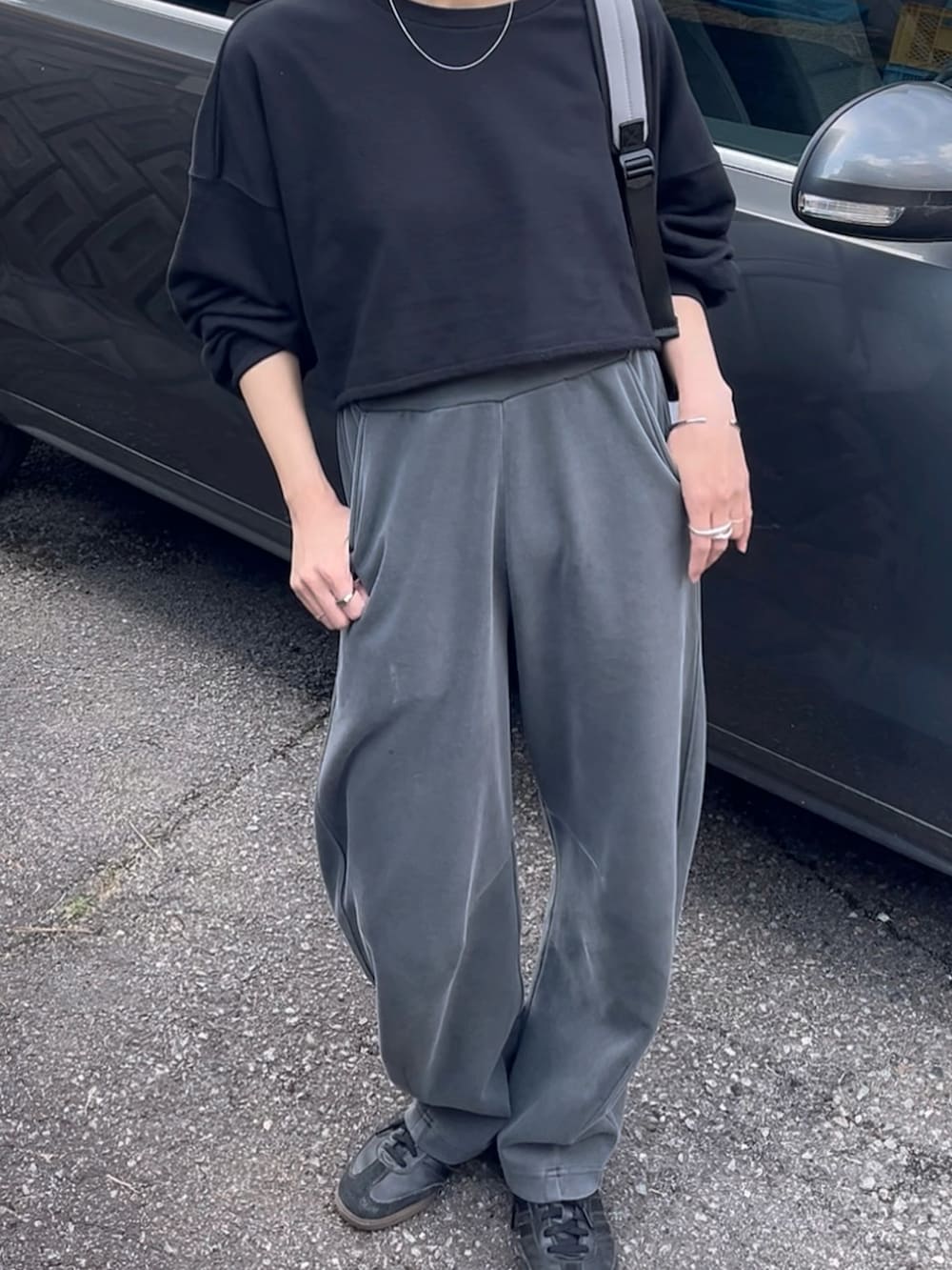 グレー系のバックパック/リュック、グレー系のパンツ、ブラック系のスニーカーを着用したレディースの春コーディネートの2枚目の写真