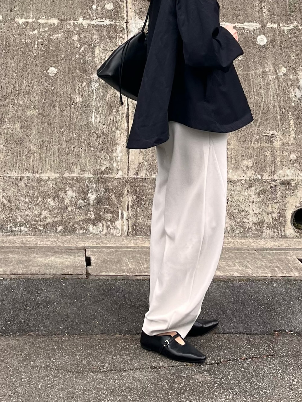 ブラック系のマウンテンパーカー、ホワイト系のその他パンツ、ブラック系のパンプスを着用したレディースの春コーディネートの4枚目の写真