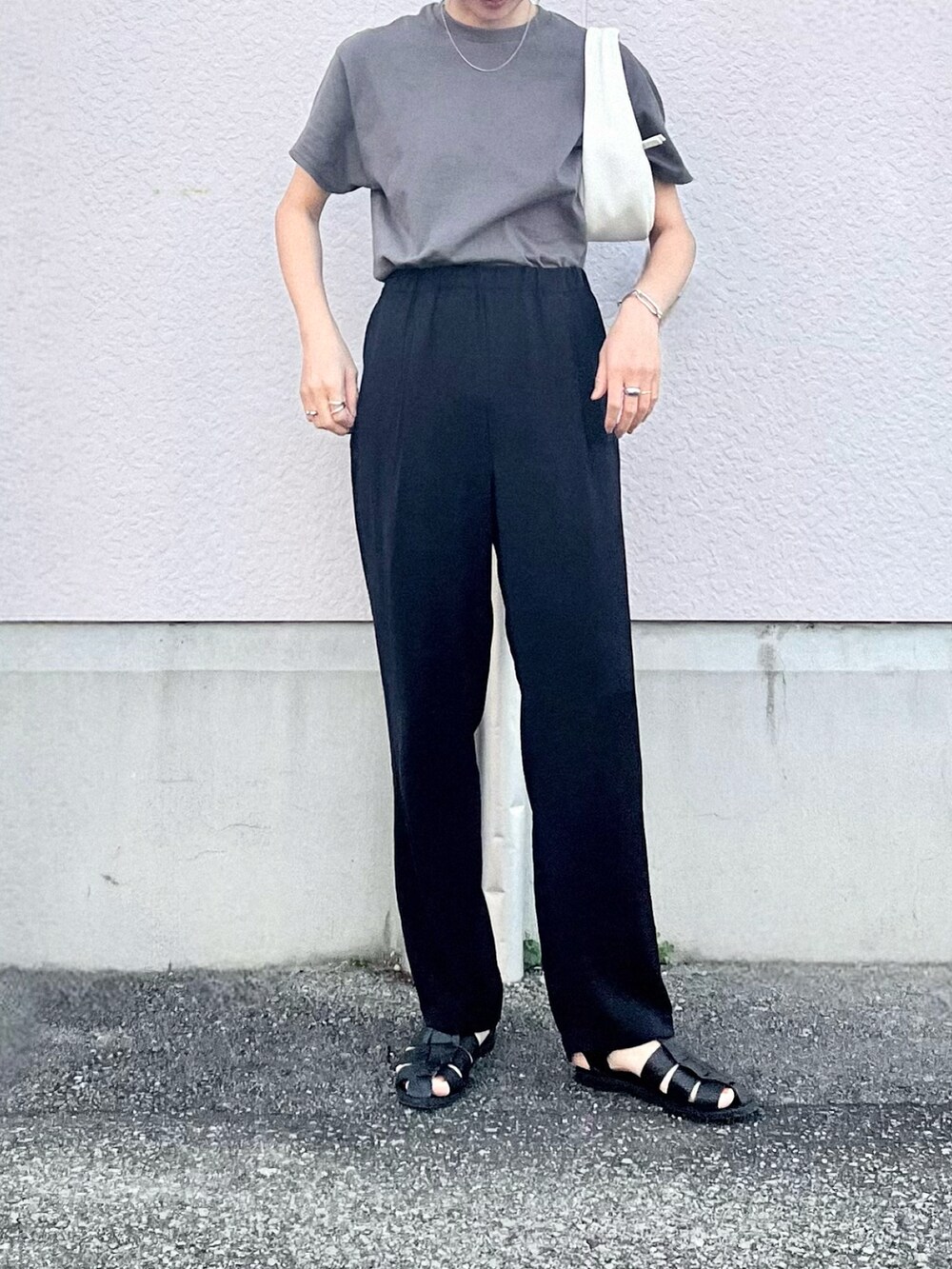 グレー系のTシャツ/カットソー、ブラック系のその他パンツ、ホワイト系のハンドバッグを着用したレディースの夏コーディネートの2枚目の写真