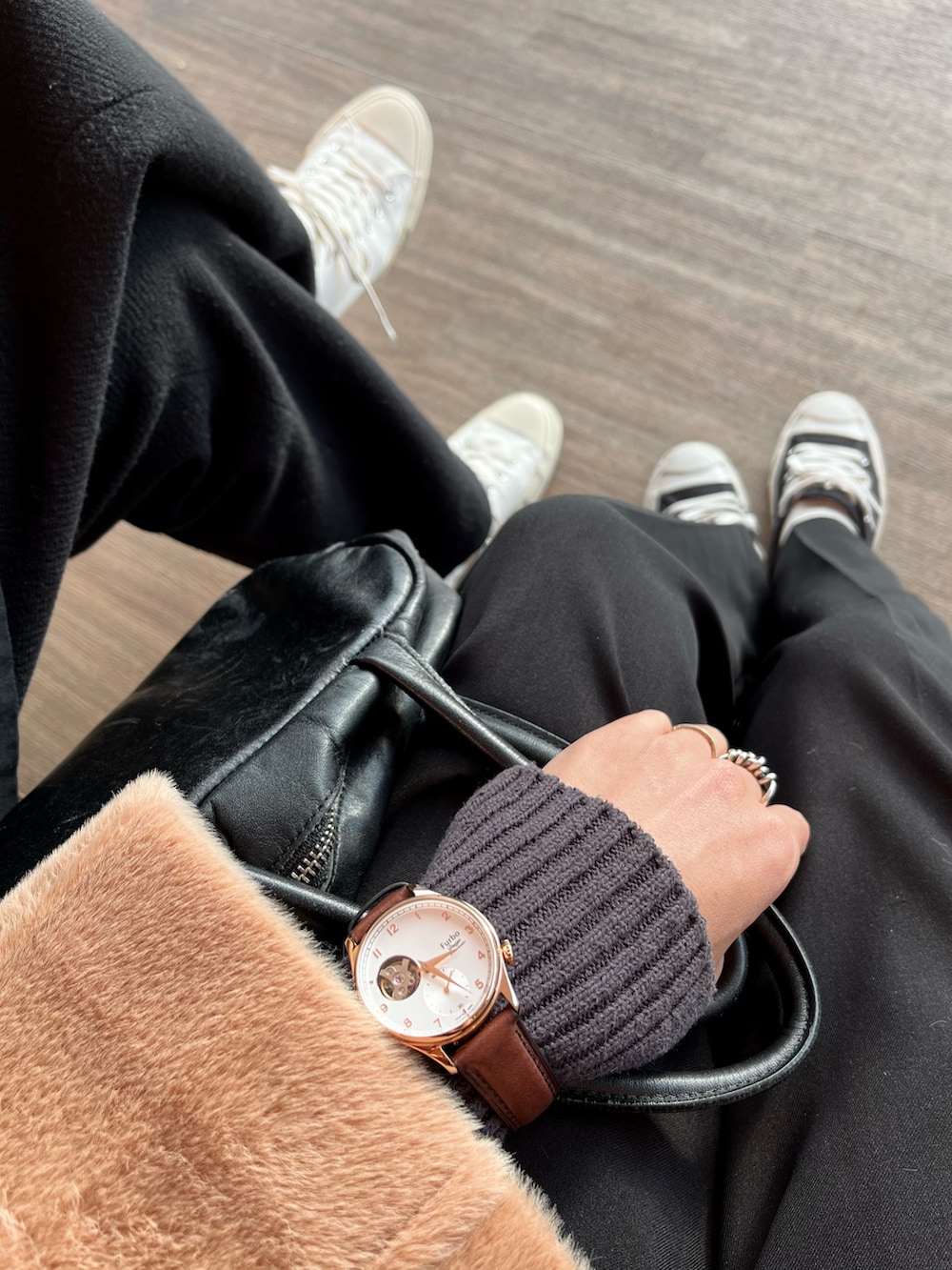 ブラウン系のステンカラーコート、ブラック系のスラックス、ブラック系のスニーカーを着用したレディースの冬コーディネートの2枚目の写真