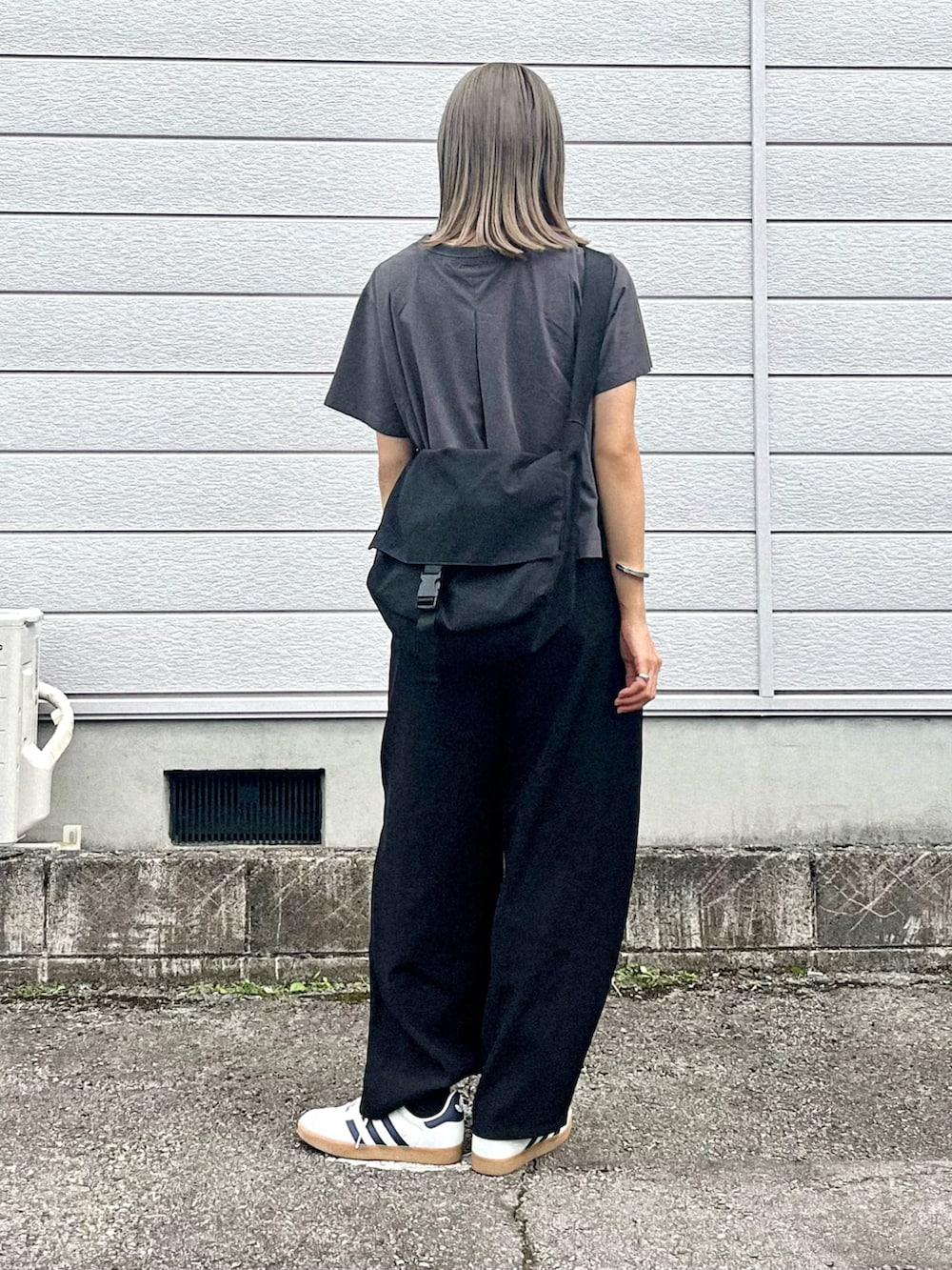 グレー系のTシャツ/カットソー、ブラック系のその他パンツ、ホワイト系のスニーカーを着用したレディースの夏コーディネートの2枚目の写真