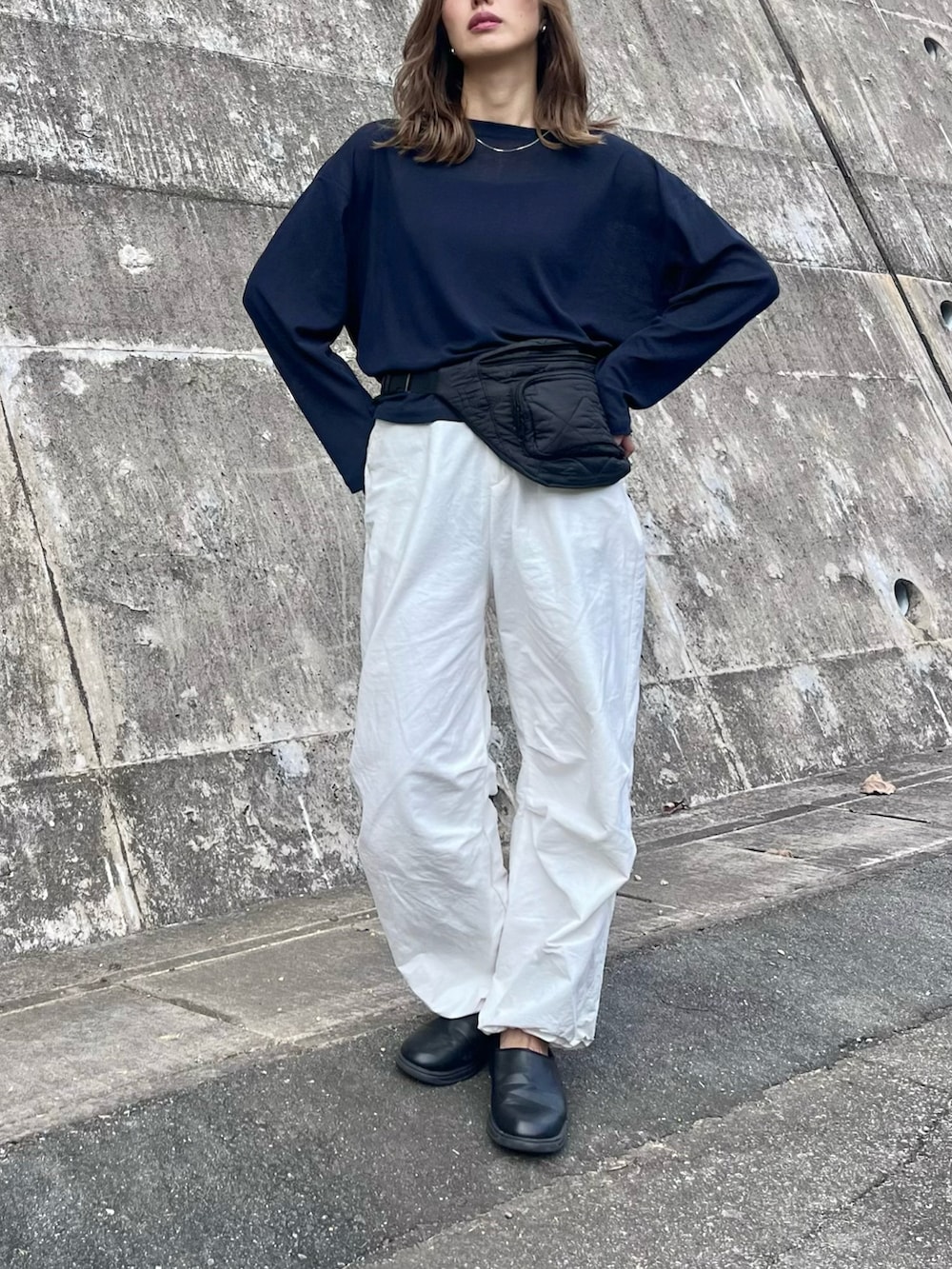 ブルー系のTシャツ/カットソー、ブラック系のスニーカー、ブラック系のボディバッグ/ウエストポーチを着用したレディースの秋コーディネートの2枚目の写真