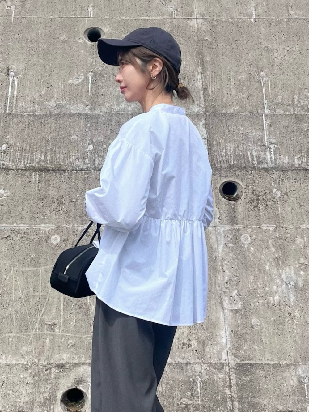 ホワイト系のシャツ/ブラウス、ブラック系のボストンバッグ、グレー系のその他パンツを着用したレディースの春コーディネートの2枚目の写真