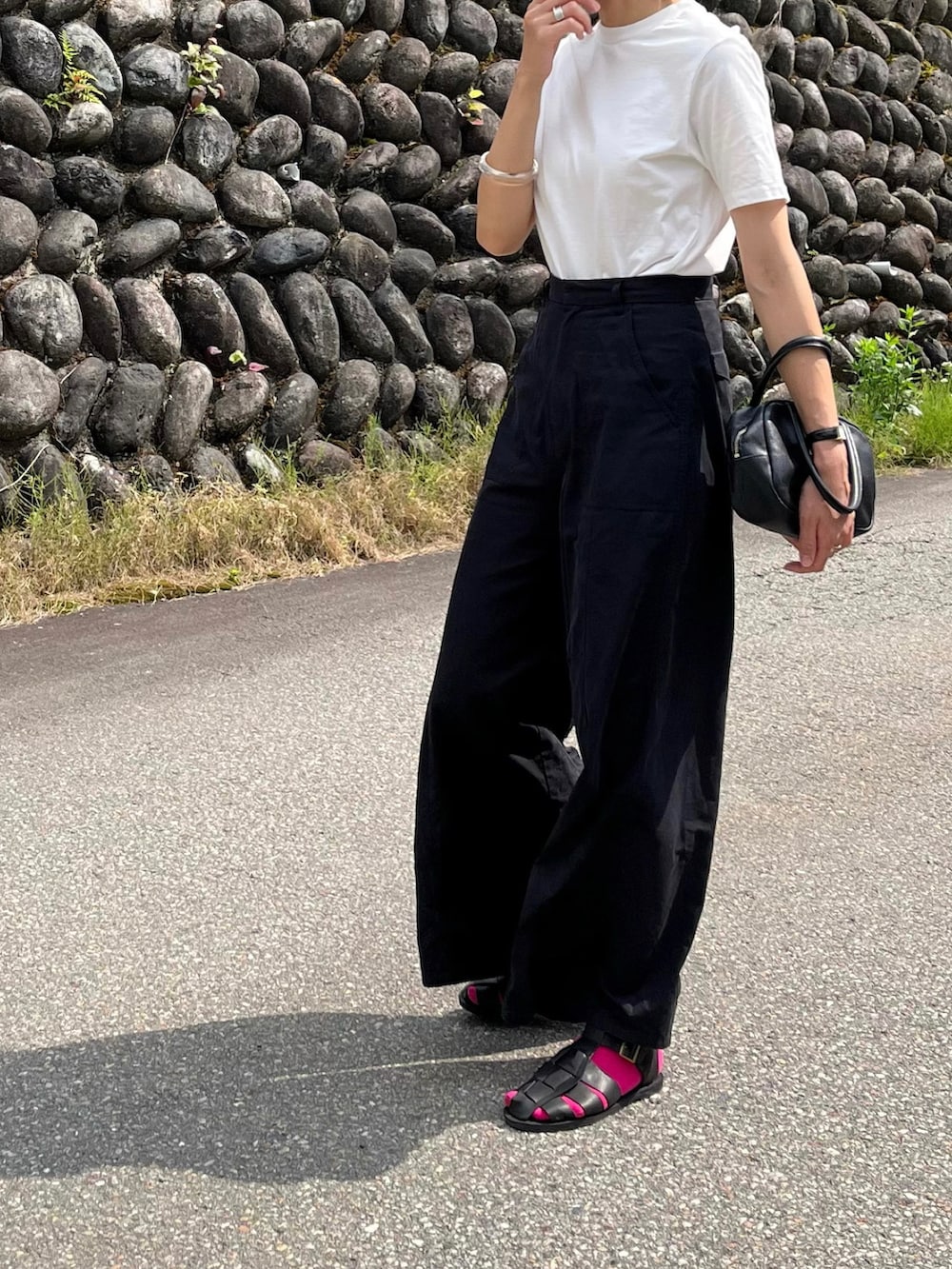 ホワイト系のTシャツ/カットソー、ブラック系のサンダル、ブラック系のボストンバッグを着用したレディースの夏コーディネートの2枚目の写真