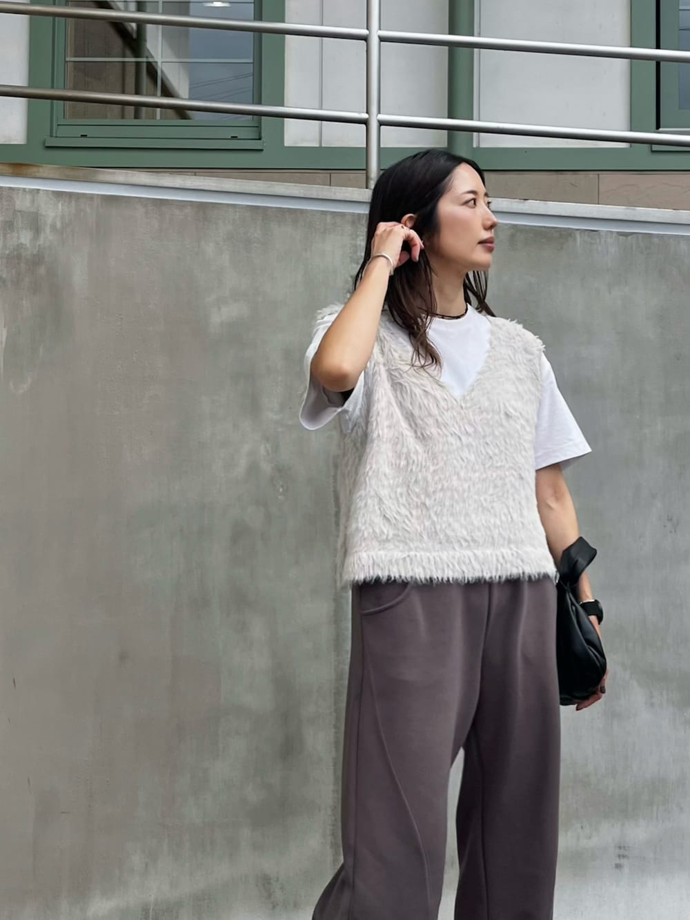 グレー系のその他パンツ、ホワイト系のベスト、ブラック系のレインシューズを着用したレディースの秋コーディネートの2枚目の写真