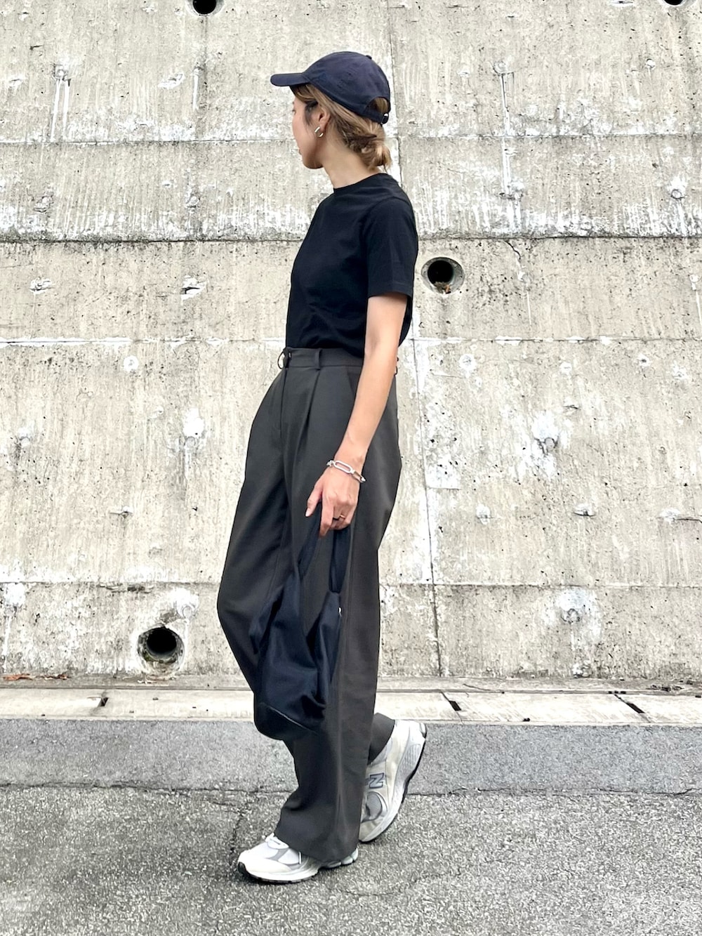 ブラック系のTシャツ/カットソー、ブラック系のハンドバッグ、グリーン系のスラックスを着用したレディースの夏コーディネートの2枚目の写真