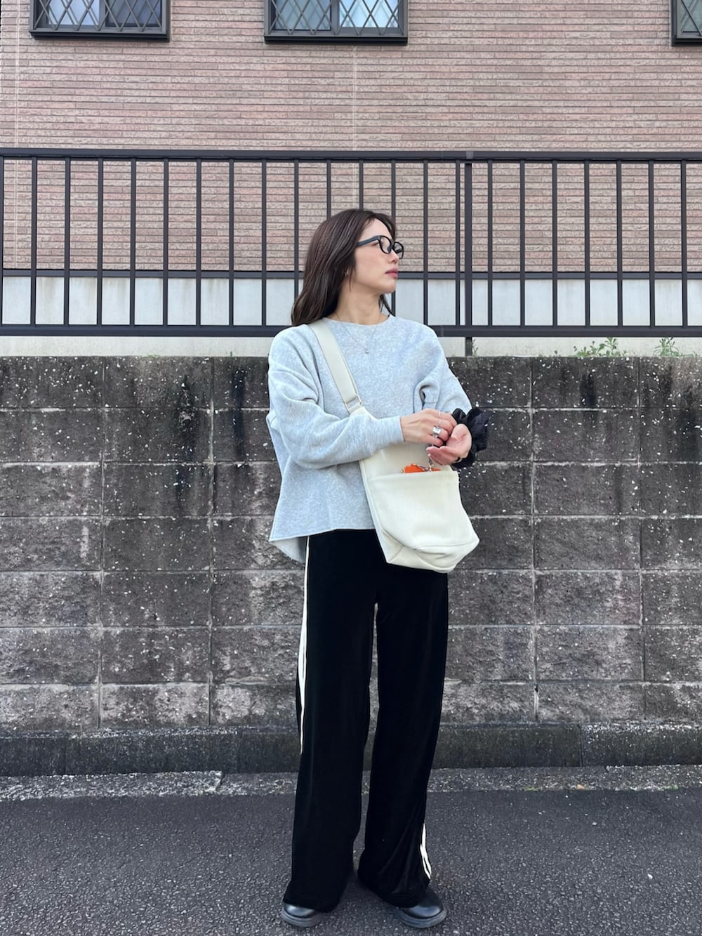 ブラック系のその他パンツ、ホワイト系のショルダーバッグ、ブラック系のスニーカーを着用したレディースの冬コーディネートの2枚目の写真