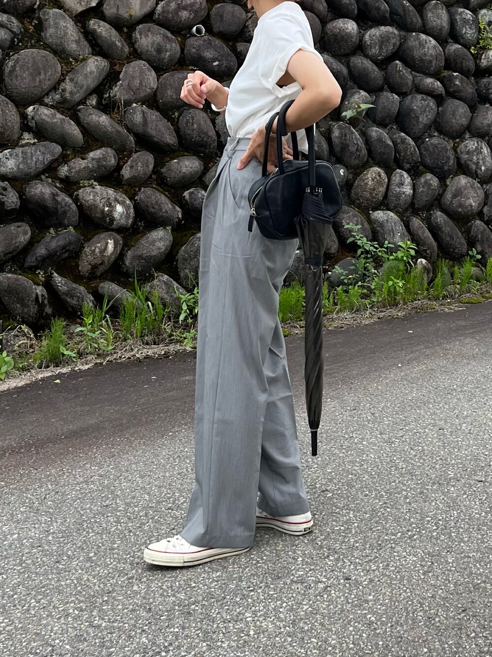 ホワイト系のスニーカー、グレー系のスラックス、ホワイト系のTシャツ/カットソーを着用したレディースの夏コーディネートの2枚目の写真