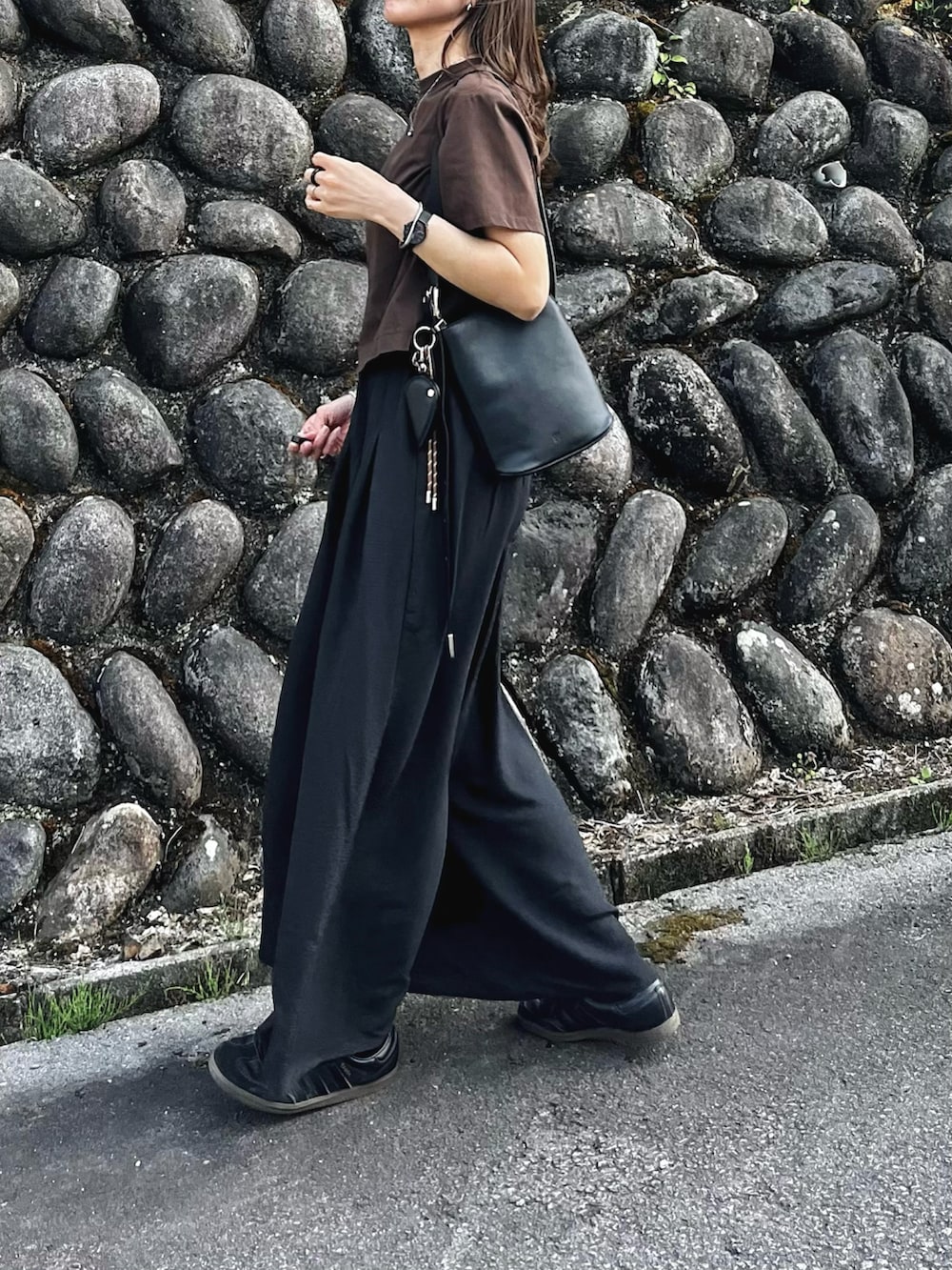 ブラック系のその他パンツ、ブラウン系のニット/セーター、ブラック系のバッグを着用したレディースの春コーディネートの3枚目の写真