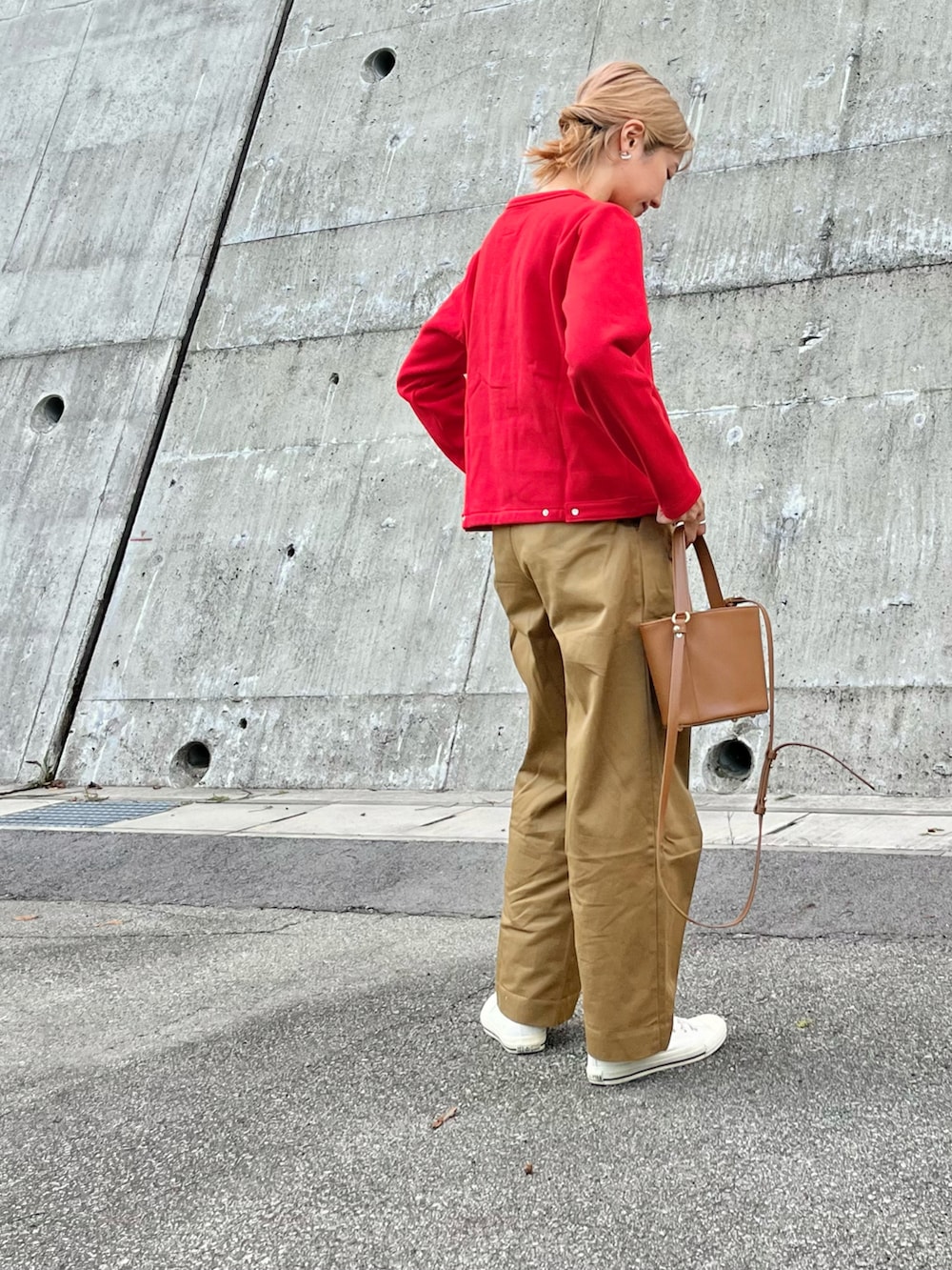 レッド系のカーディガン/ボレロ、イエロー系のハンドバッグ、ホワイト系のスニーカーを着用したレディースの秋コーディネートの2枚目の写真