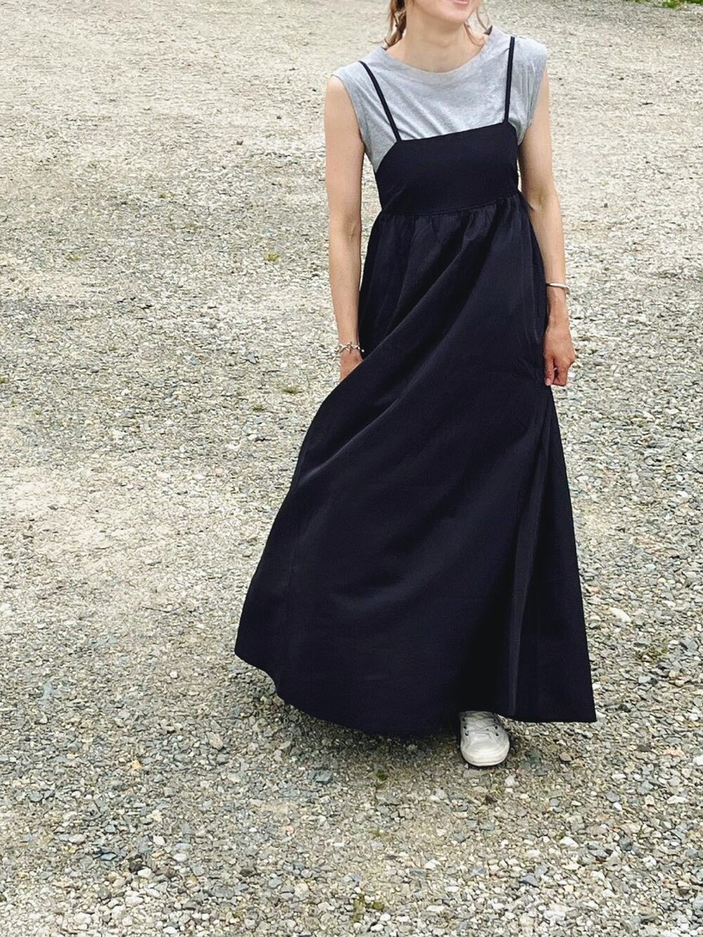 ブラック系のワンピース、グレー系のタンクトップ、ホワイト系のスニーカーを着用したレディースの春コーディネートの2枚目の写真