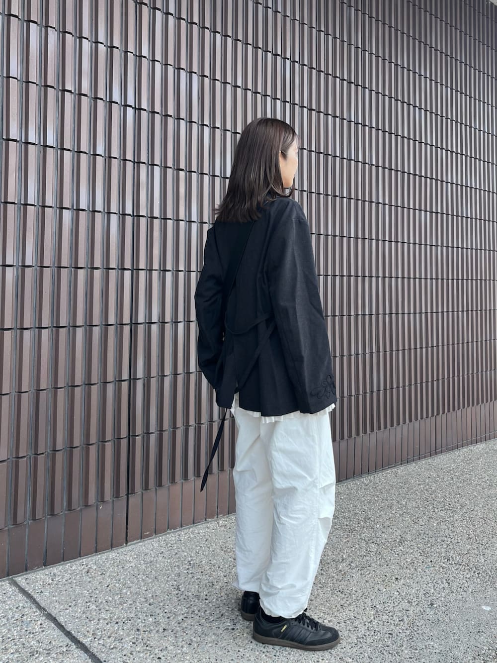 ブラック系のテーラードジャケット、ブラック系のショルダーバッグ、ホワイト系のTシャツ/カットソーを着用したレディースの秋コーディネートの2枚目の写真
