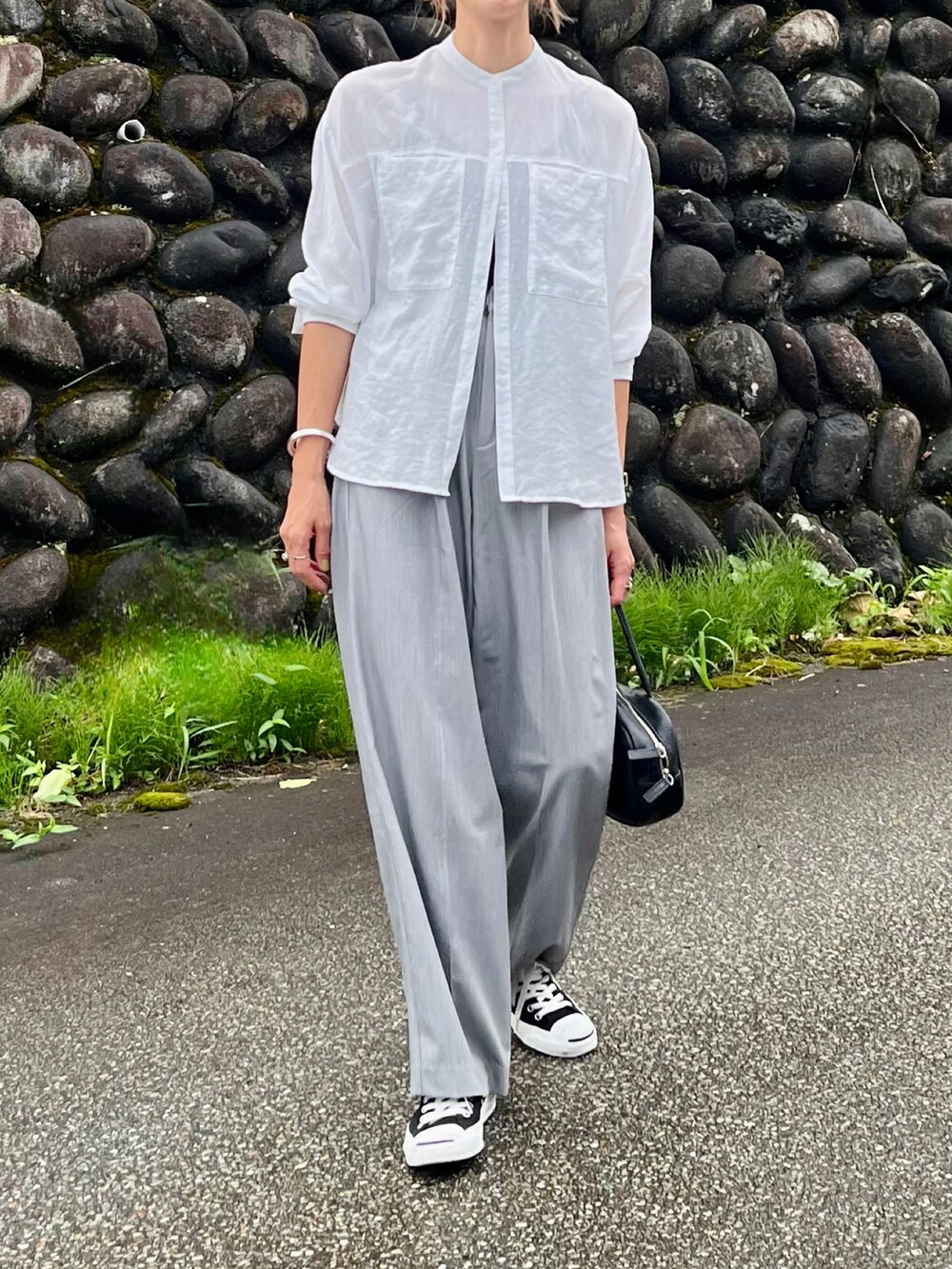 ホワイト系のシャツ/ブラウス、グレー系のスラックスを着用したレディースの夏コーディネートの2枚目の写真