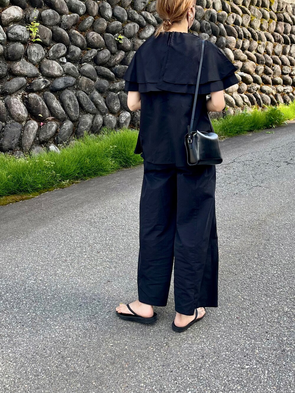 ブラック系のシャツ/ブラウス、ブラック系のショルダーバッグ、ブラック系のサンダルを着用したレディースの春コーディネートの2枚目の写真