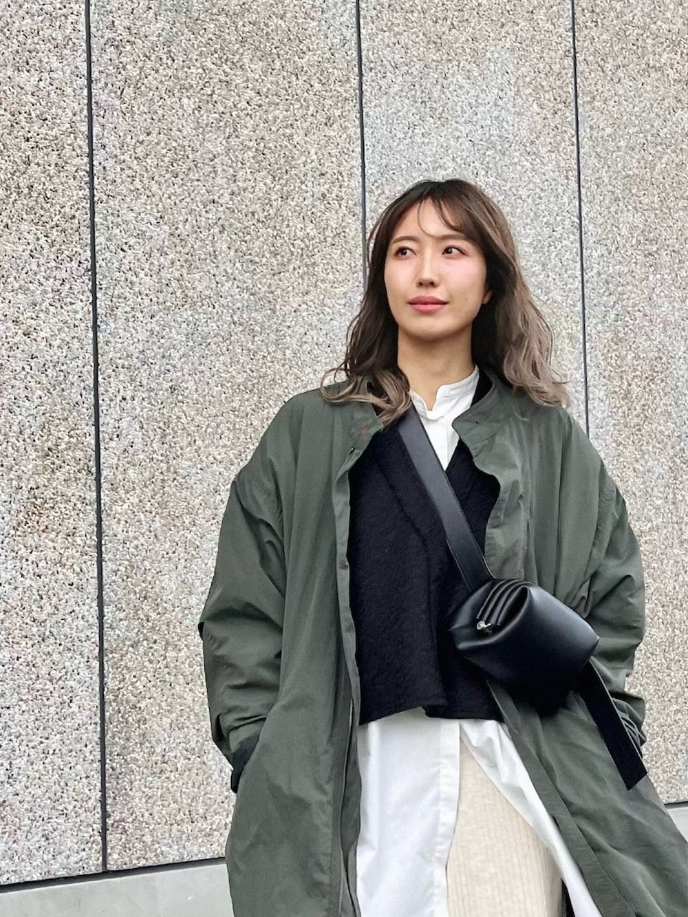 ブラック系のカーディガン/ボレロ、ブラック系のハンドバッグ、ホワイト系のその他パンツを着用したレディースの冬コーディネートの2枚目の写真