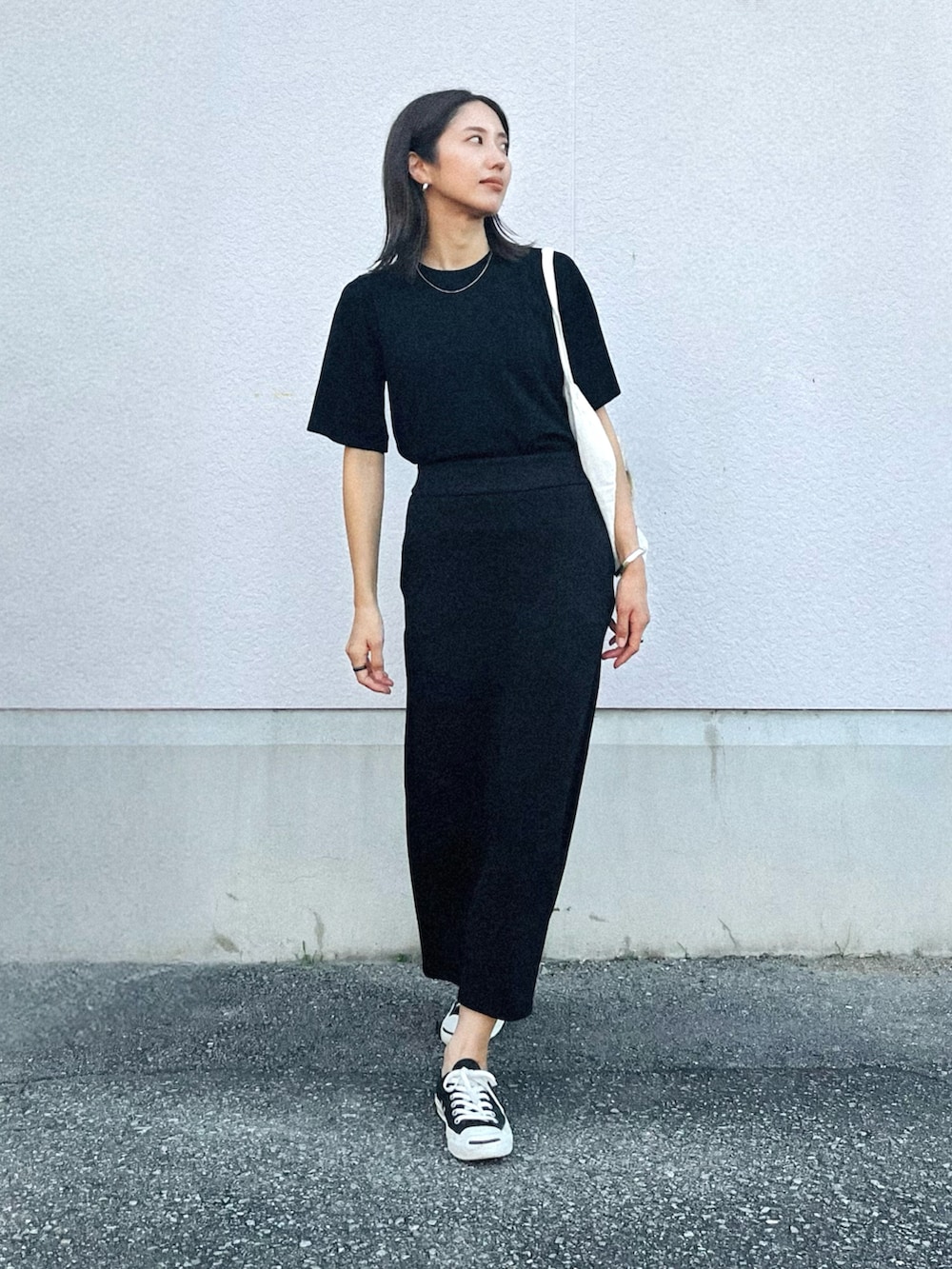 ブラック系のニット/セーター、ブラック系のスカート、ブラック系のスニーカーを着用したレディースの夏コーディネートの2枚目の写真