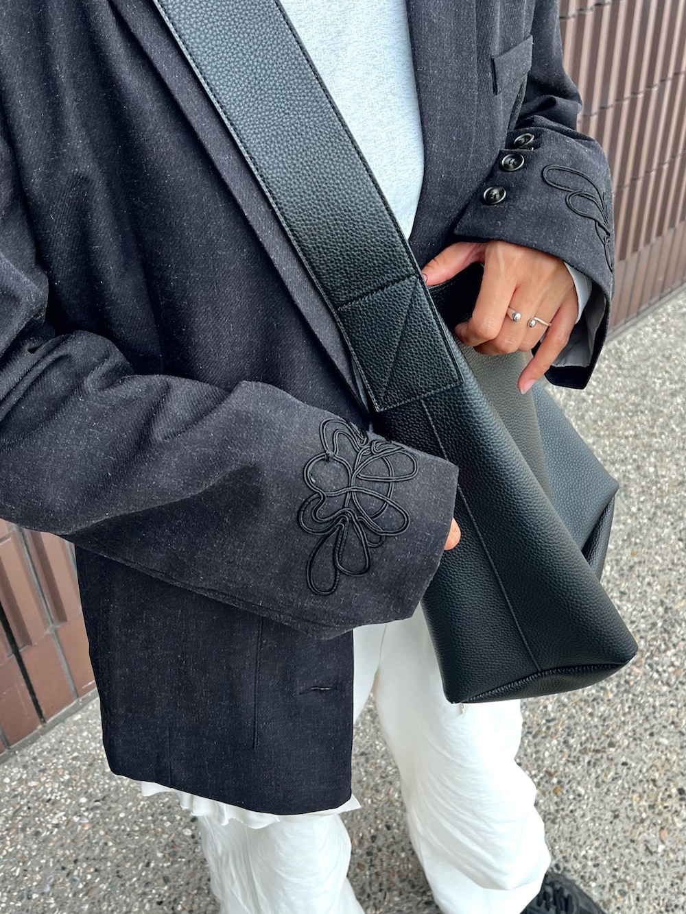 ブラック系のテーラードジャケット、ブラック系のショルダーバッグ、ホワイト系のTシャツ/カットソーを着用したレディースの秋コーディネートの3枚目の写真