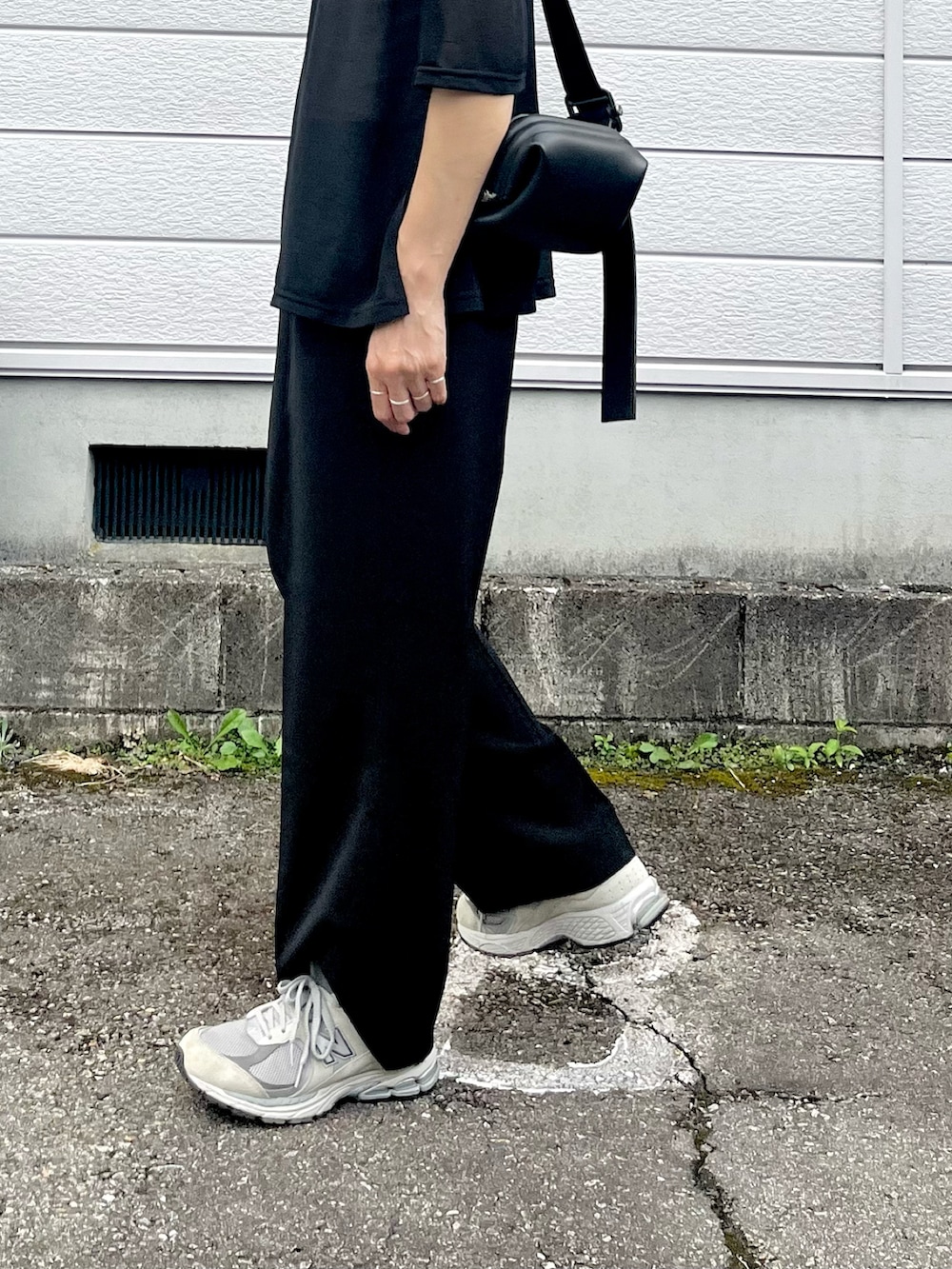 ブラック系のその他パンツ、ブラック系のハンドバッグ、シルバー系のネックレスを着用したレディースの夏コーディネートの2枚目の写真