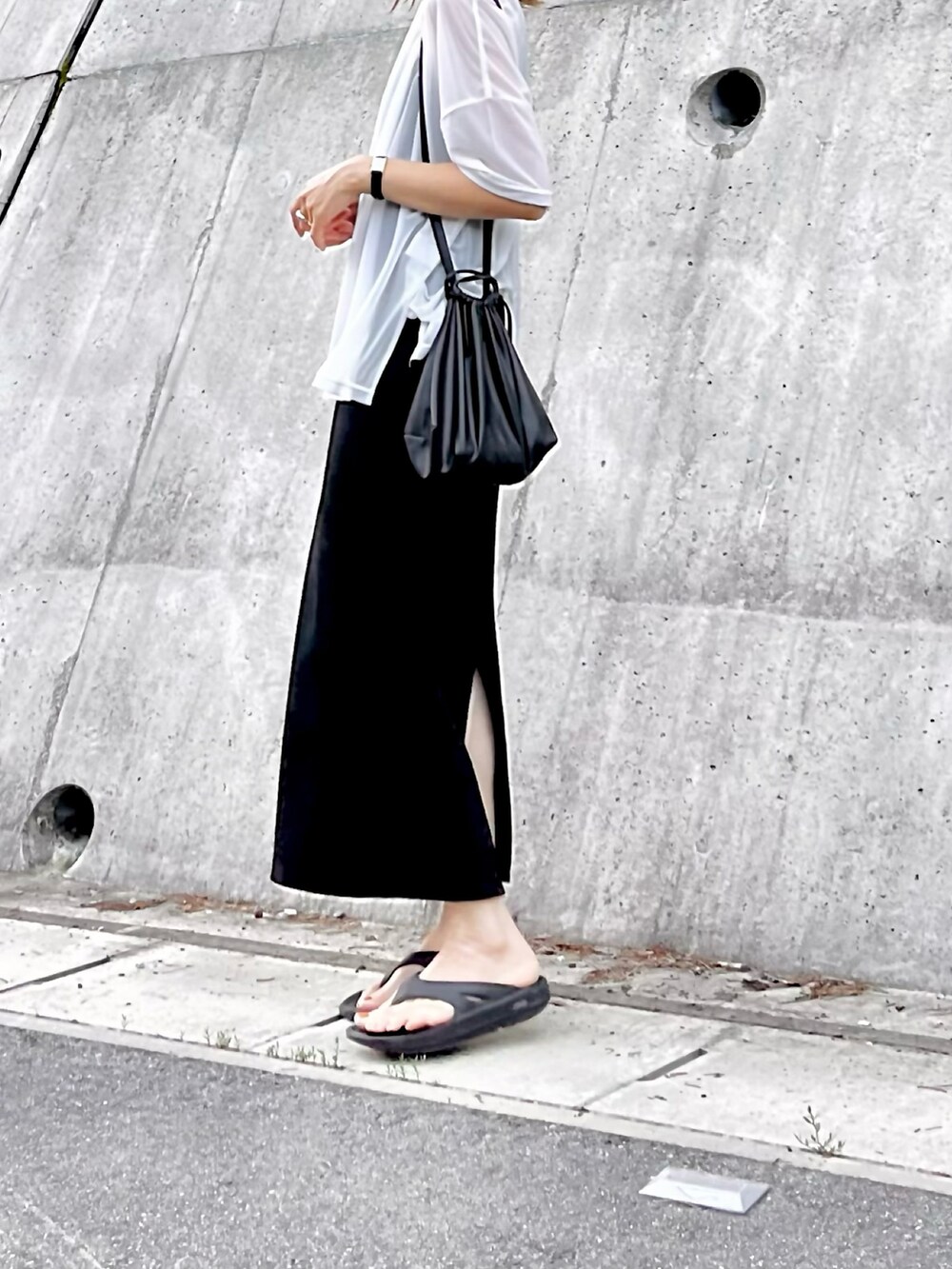 ブラック系のワンピース、ホワイト系のTシャツ/カットソー、ブラック系のショルダーバッグを着用したレディースの夏コーディネートの2枚目の写真