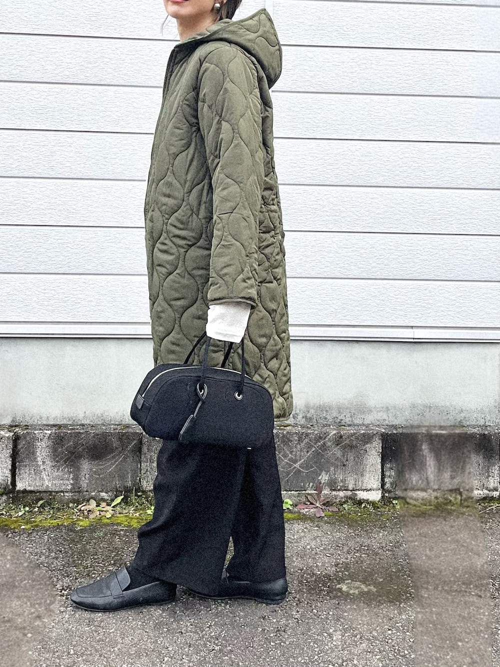 グリーン系のその他アウター、ホワイト系のベスト、ブラック系のボストンバッグを着用したレディースの秋コーディネートの2枚目の写真