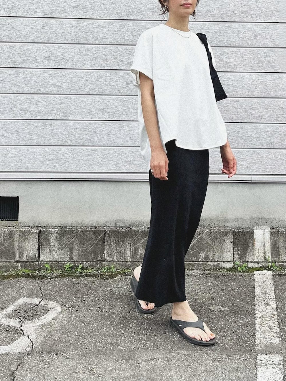 ホワイト系のTシャツ/カットソー、ブラック系のスカート、ブラック系のサンダルを着用したレディースの夏コーディネートの2枚目の写真