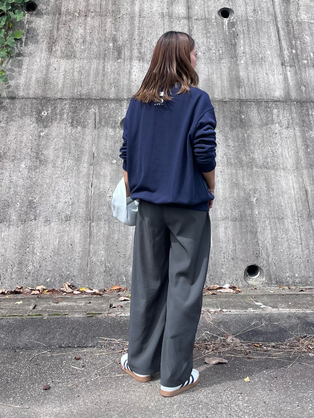 ブルー系のスウェット、グレー系のその他パンツ、ホワイト系のスニーカーを着用したレディースの秋コーディネートの2枚目の写真