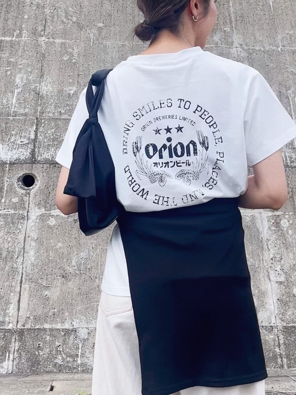 ホワイト系のTシャツ/カットソー、ホワイト系のデニムパンツ、ブラック系のサンダルを着用したレディースの夏コーディネートの3枚目の写真