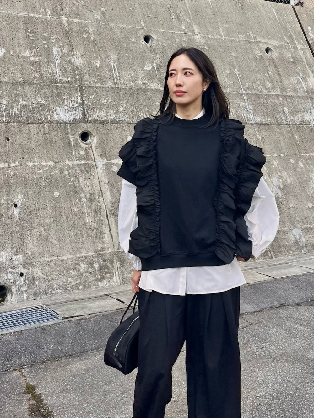 ブラック系のボストンバッグ、ブラック系のスラックス、ブラック系のスウェットを着用したレディースの春コーディネートの5枚目の写真