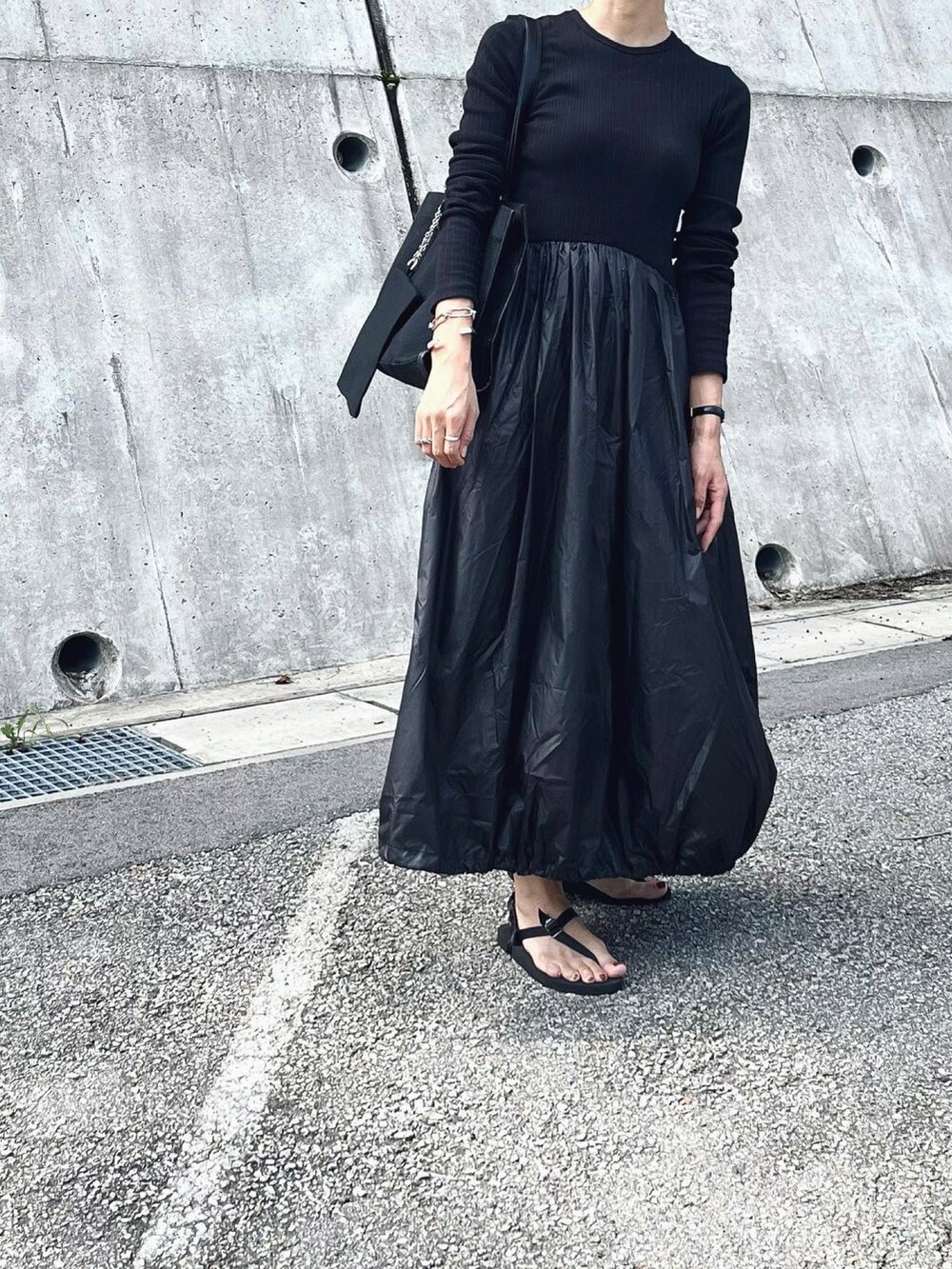 ブラック系のトートバッグ、ブラック系のワンピース、ブラック系のサンダルを着用したレディースの夏コーディネートの2枚目の写真