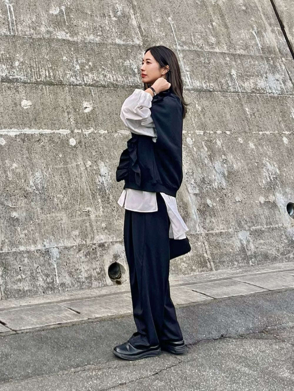 ブラック系のボストンバッグ、ブラック系のスラックス、ブラック系のスウェットを着用したレディースの春コーディネートの4枚目の写真