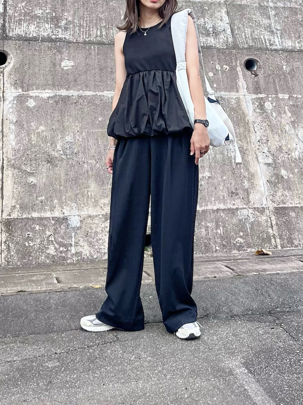 ブラック系のアンサンブル、ホワイト系のボディバッグ/ウエストポーチ、ピンク系の口紅/リップティント/グロスを着用したレディースの秋コーディネートの5枚目の写真