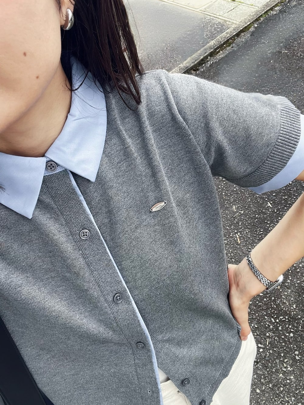 グレー系のカーディガン/ボレロ、ホワイト系のデニムパンツ、ブラック系のハンドバッグを着用したレディースの夏コーディネートの3枚目の写真