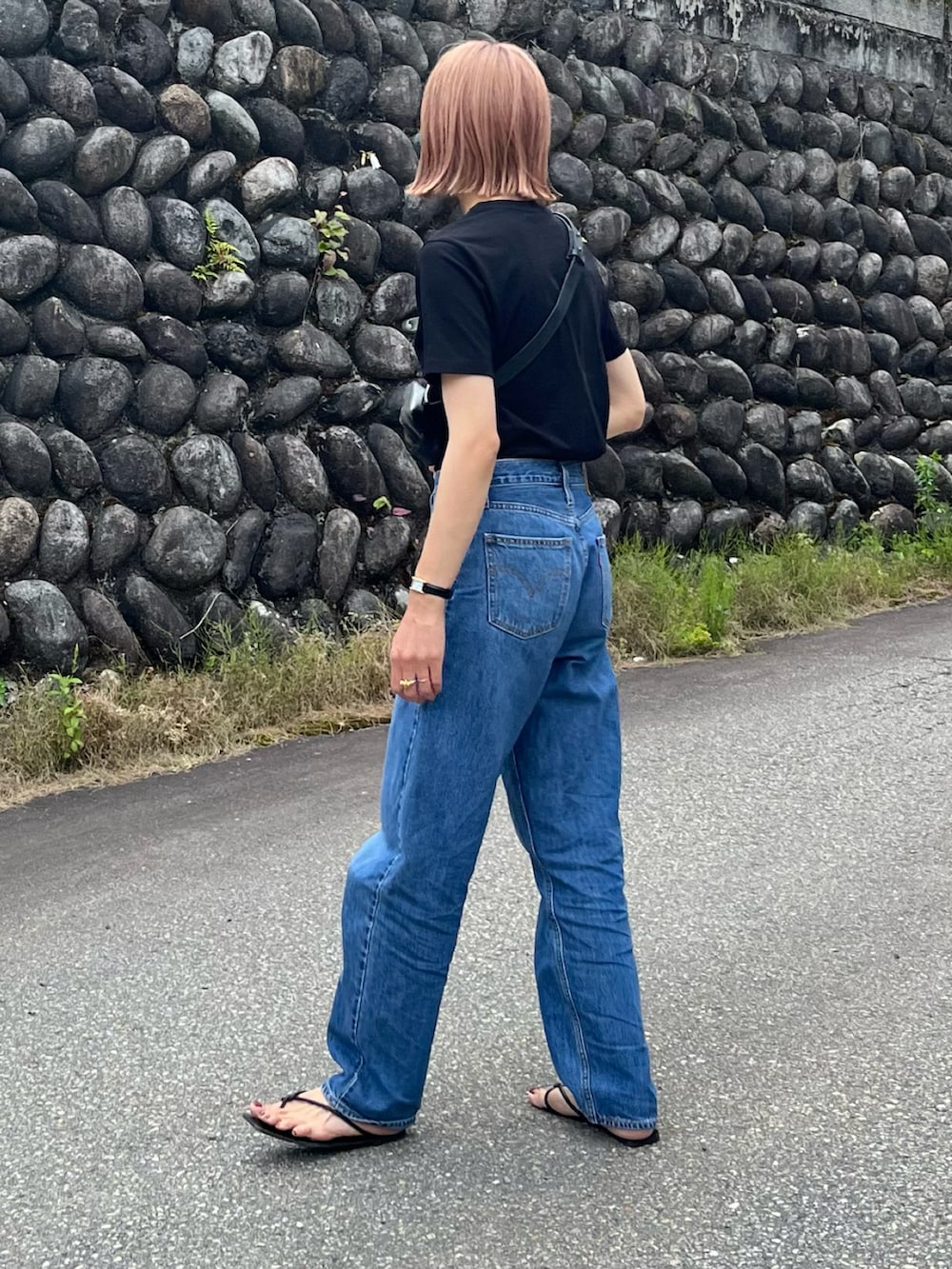 ブラック系のTシャツ/カットソー、ブルー系のデニムパンツ、ブラック系のサンダルを着用したレディースの夏コーディネートの2枚目の写真